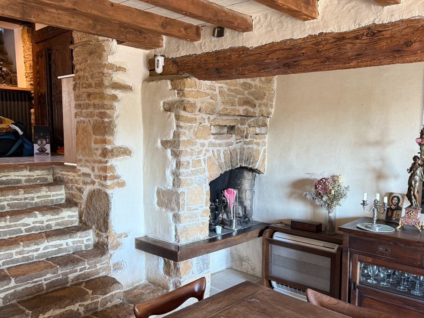 Séjour de maison avec cheminée et escalier couverts de poussière après travaux