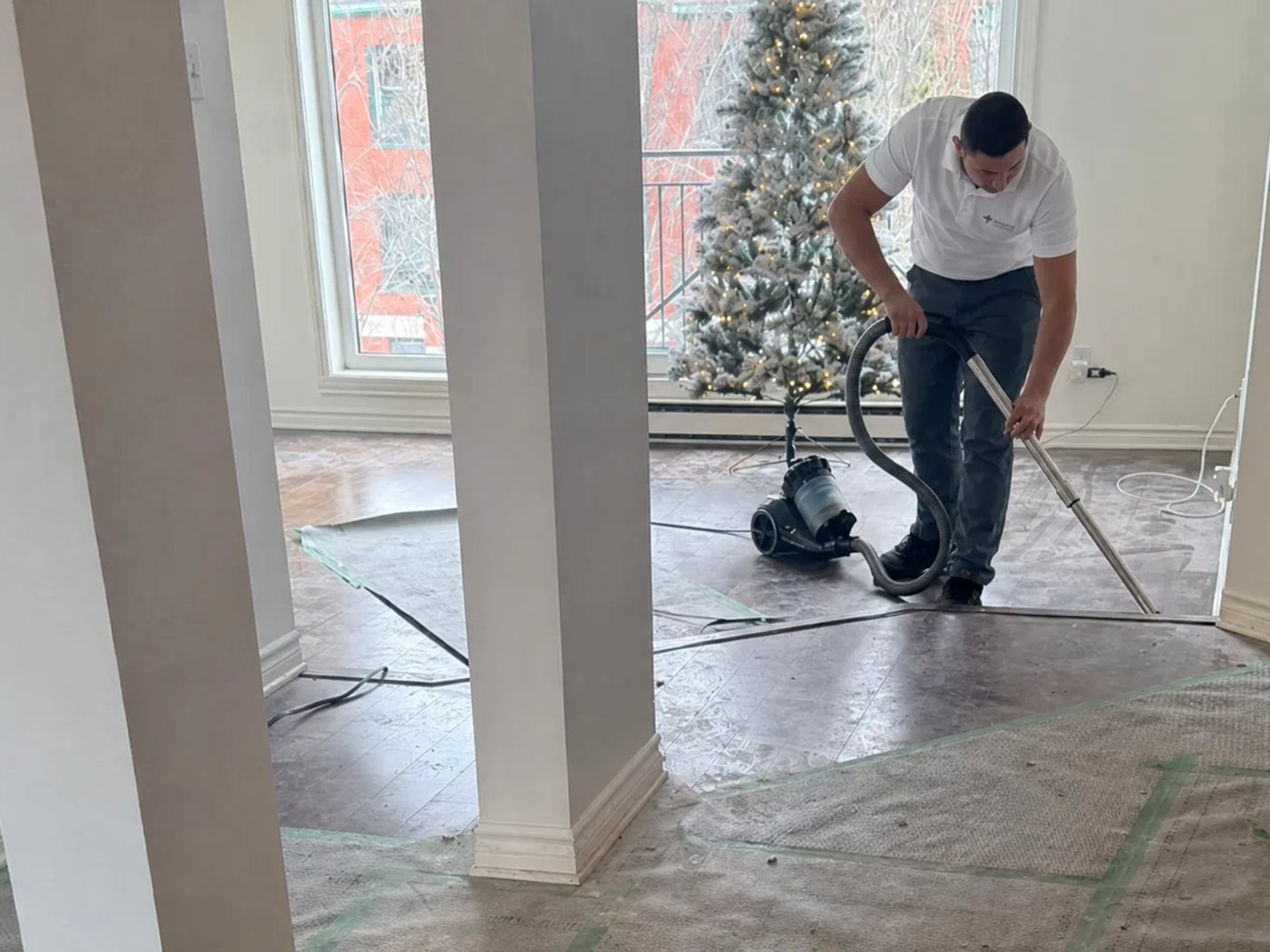 Agent Impeka aspire un sol protégé lors d'un nettoyage de fin de chantier