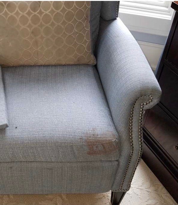 Tache de rouille oxydée sur l'assise d'un fauteuil en tissu avant nettoyage à Paris